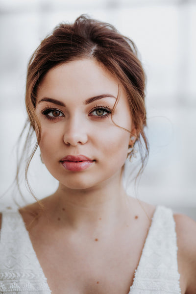 Rose gold-colored stud earrings with crystal pendants